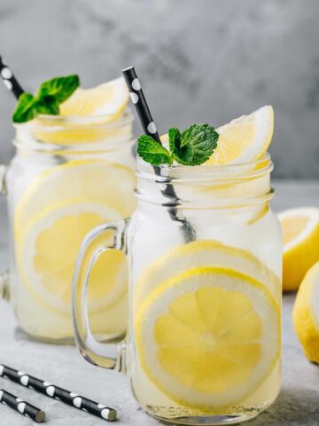 two glasses of {title:2:5} lemonade and some lemons around