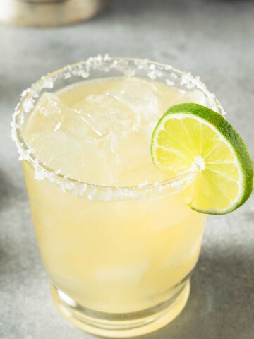 A {title:2:3} glass with a salted rim with a {title:2:3} mix and a lime wedge on the side